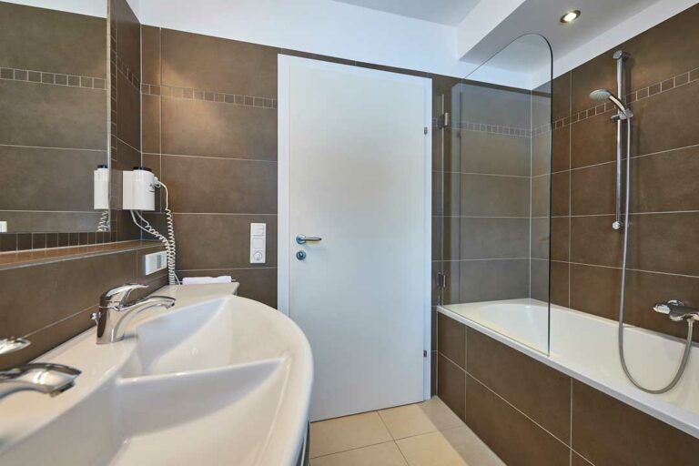 Badewanne mit Glasduschwand im Appartement Kitzblick